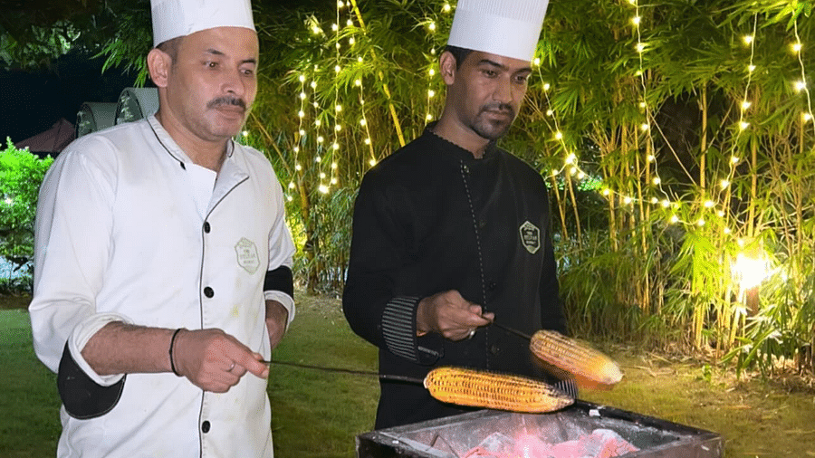 Two chefs preparing barbecue at night at  The Sylvan Retreat, Dehradun.
