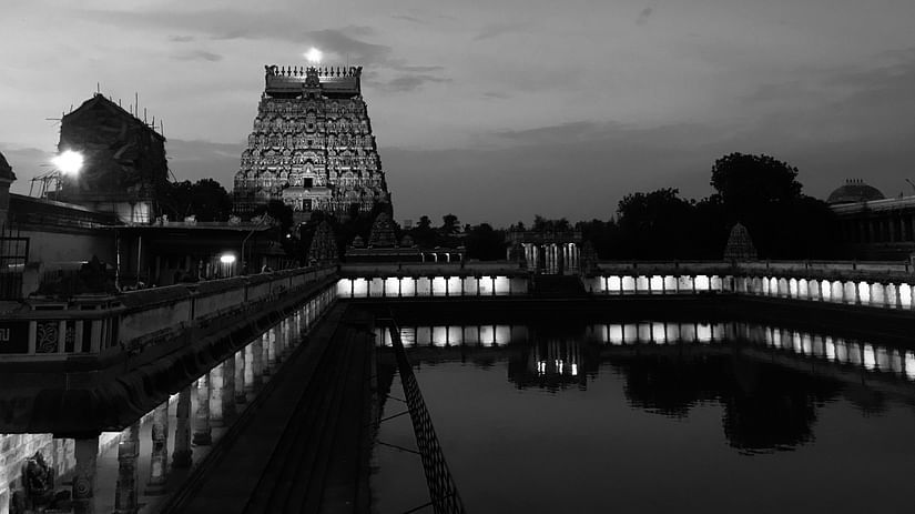 a black and white image of Varaswamy Temple facade with water view