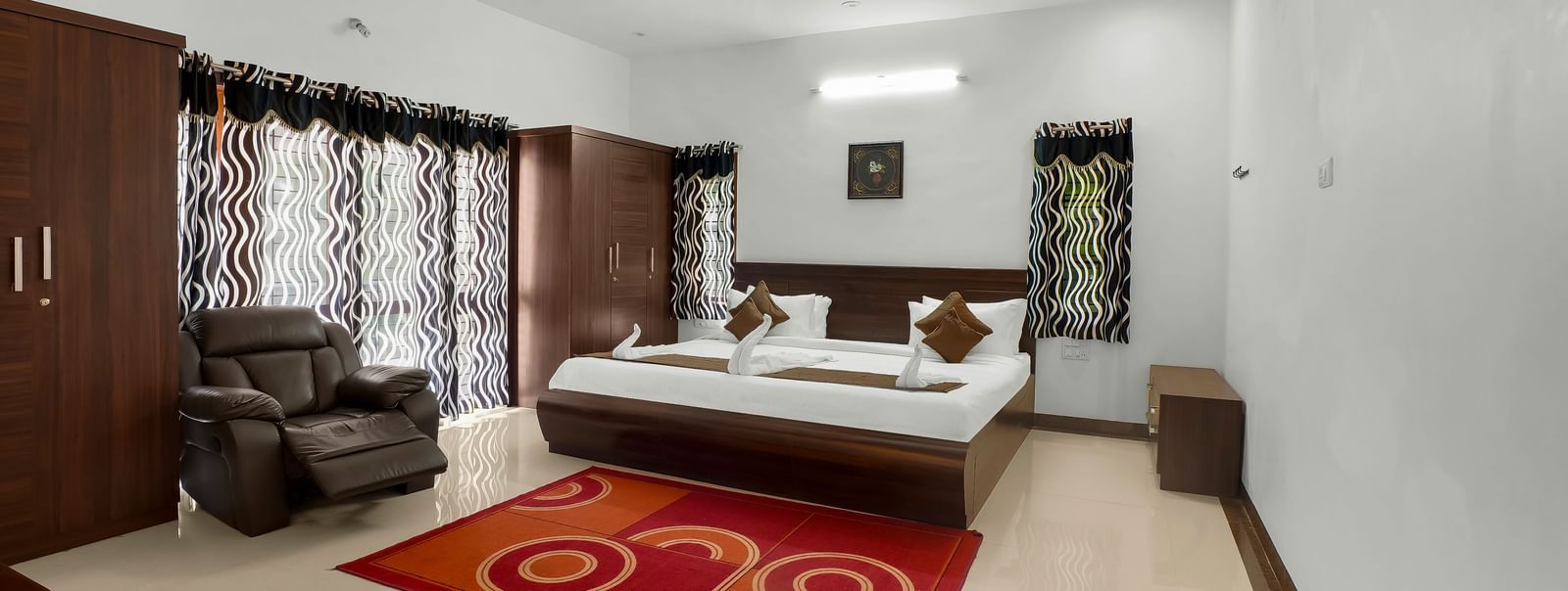 A spacious bedroom with a large bed and wooden furnishings at WOW Bungalow, Yercaud.