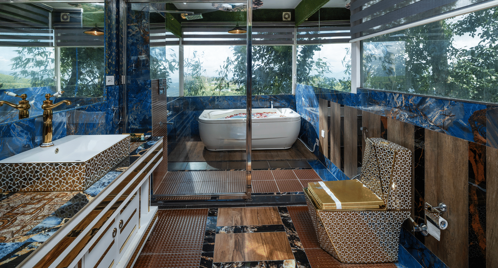 A modern bathroom of the Family Jacuzzi Room at Parakkat Nature Hotel and Resorts, Munnar featuring a shower fixture, a toilet, a sink vanity with a cabinet, a framed mirror, and a patterned floor.
