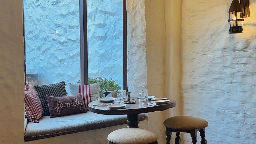 Image of a table placed next to a window where the windowpane is made into a seater at Old England Cafe - Hotel Atulyaa Taj, Agra