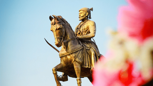 A view of shivaji maharaj's statue on his horse with blue sky in the background.