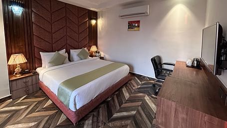A deluxe room at DLS Grand Luxotica, Dehradun featuring a double bed in the middle of the room