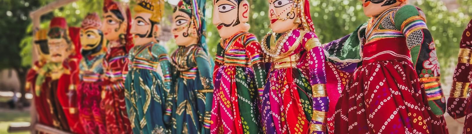 An image of a puppet show with vibrant rajasthani dolls