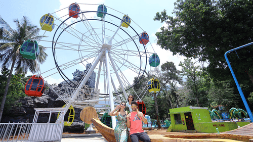 A Ferris wheel with people sitting at the entrance, posing for a picture - Black Thunder
