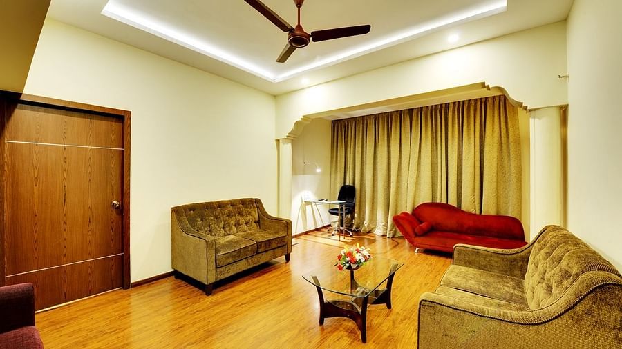 Suite with plush red sofa and wooden flooring