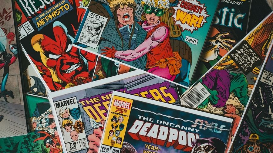 A collection of assorted comic books overlapping each other. Visible titles include Deadpool and other superhero-themed comics, featuring colorful illustrations and dynamic characters on the covers.