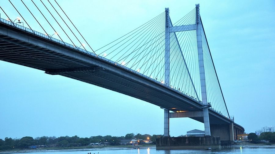 view of howrah bridge and boats cruising beneath the bridge on the river