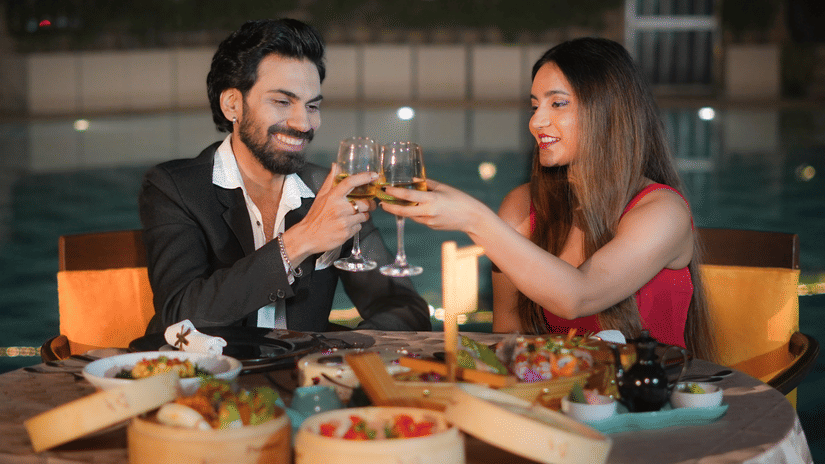 A man and a woman at The Suryaa New Delhi enjoying candlelit outdoor dining at night