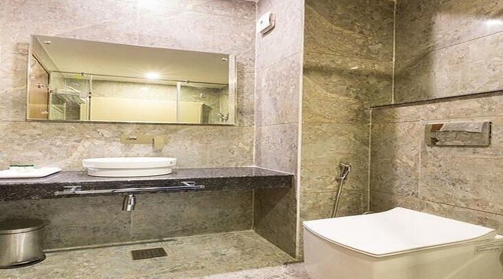 image of a modern bathroom with transparent glass doors at the family room - ZENQ SIGNATURE INN, MCLEODGANJ