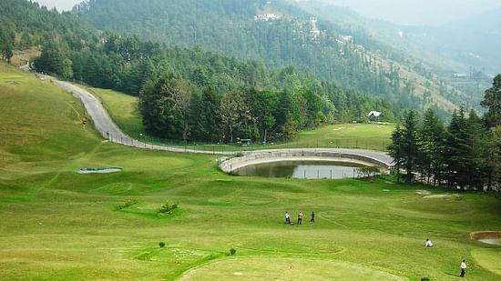 Scenic golf course with rolling green fairways, mountain views, and circular putting green at The Manor Wellness & Sports Hotel