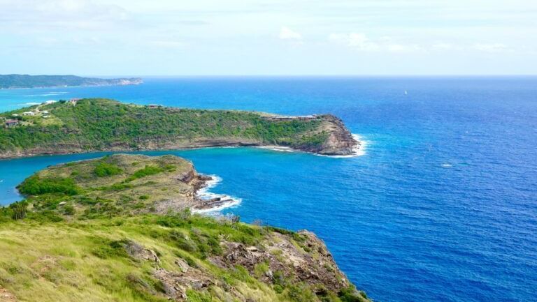 Cliffside view of Antigua’s rugged coastline and turquoise sea.