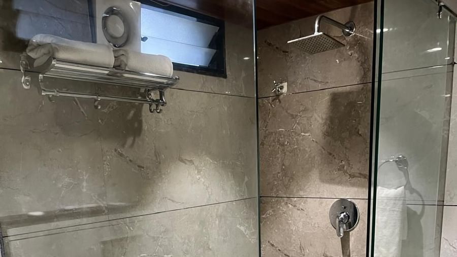 Contemporary bathroom with glass shower enclosure at Hotel Mumbai House, Vijay Nagar, Indore, designed with modern fittings and sleek finishes.