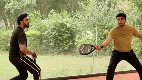 Karma Chalets | Two men playing with bats.