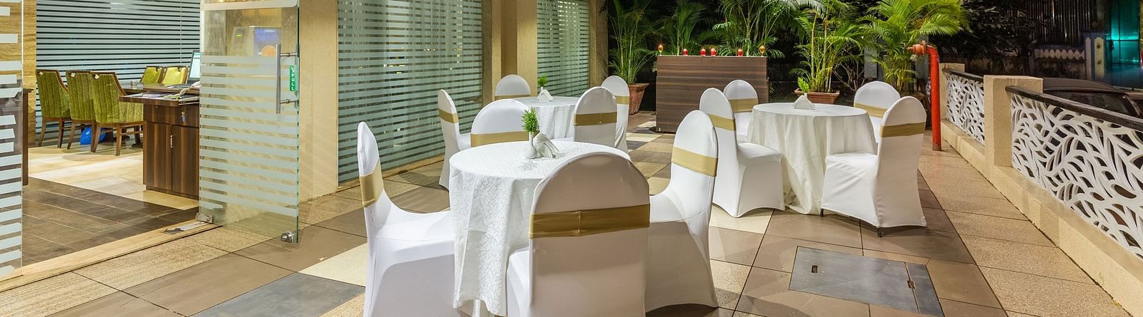 Image of an outdoor seating area with tables and chairs at Calux Grand Inn, Calangute.