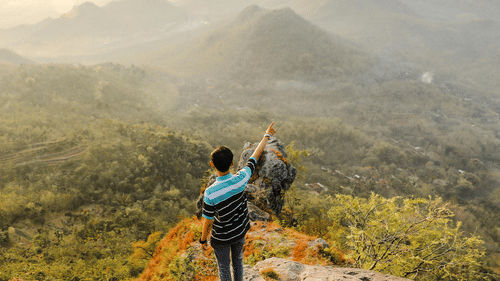 a person on a hilltop Enjoying the scenic view