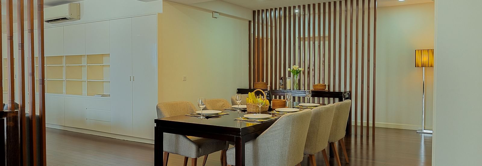 A dining area with a wooden table, chairs, and a chandelier overhead | Penthouse | Central Mansions, Phnom Penh