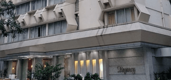 Facade image of Regency Hotel, Mumbai with a car parked outside at the entrance.