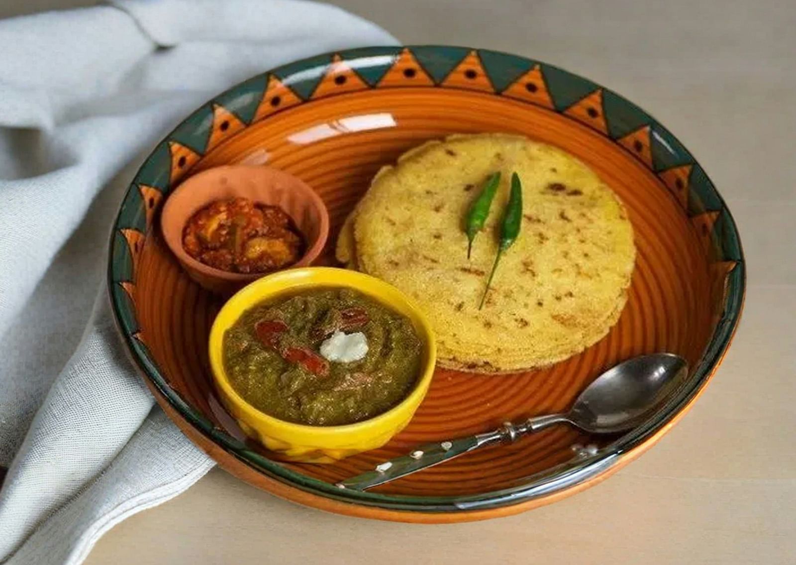 An overview of maharashtrian cuisine with flatbread and two side dishes on a plate.