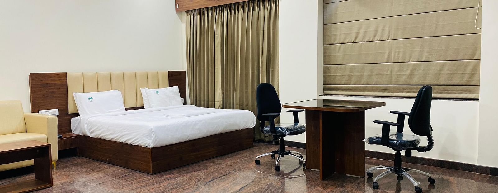 Premium suite with king bed, work desk, and warm tones for business or leisure stays at Hotel Sahara Tree.