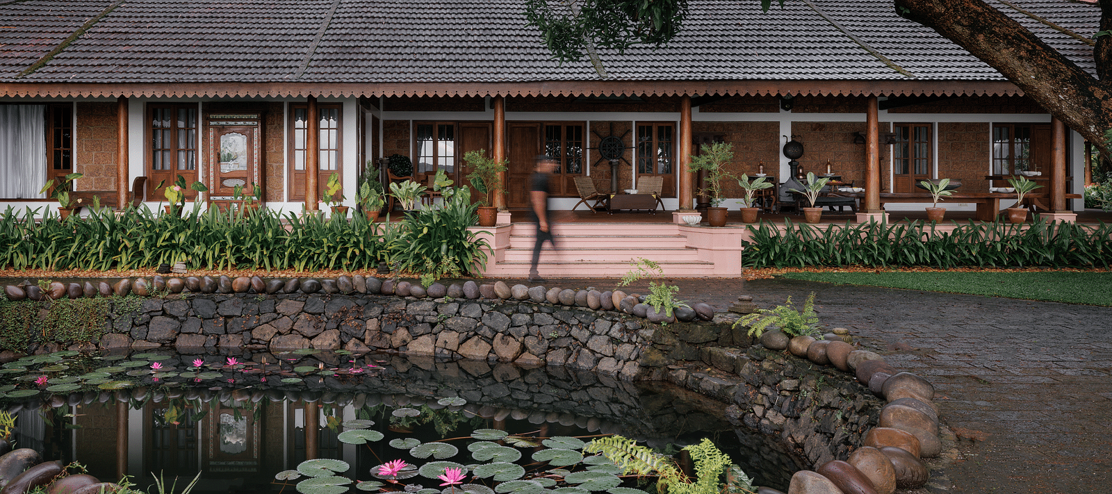 A facade image of BluSalzz Villas - Muhamma Resort, Alleppey with a pond in front of the resort