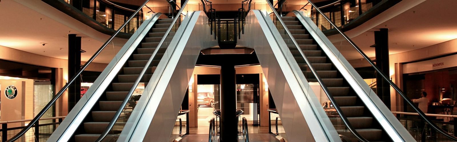 two escalators taking people up to and down from the next floor.