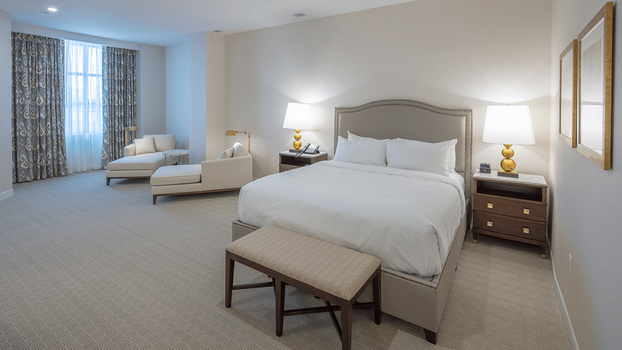 Lakeview King Room featuring a plush bed with lamps on both sides on nightstands and seating space by the window