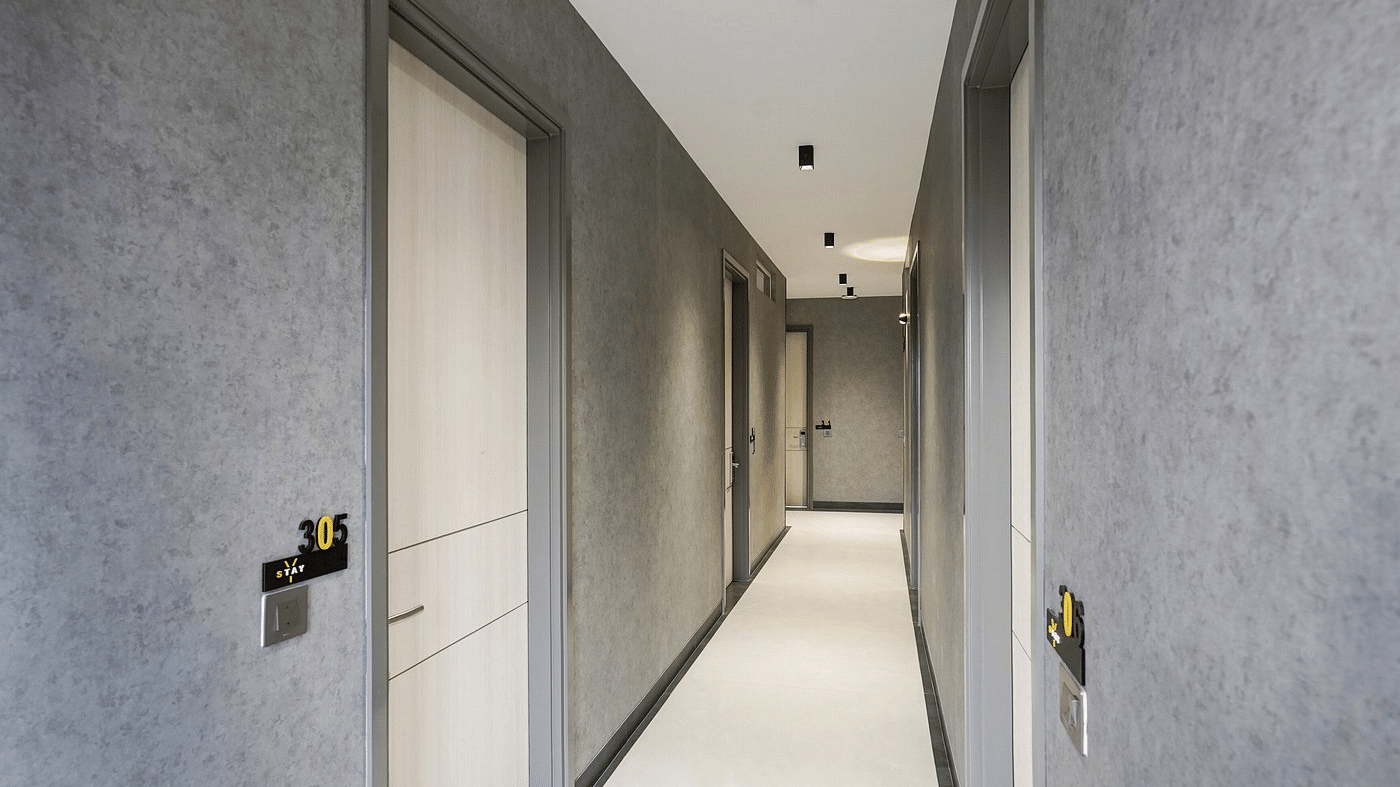 Corridor of Lime Tree Hotels & Service Apartment Private Limited featuring guest room doors along a hallway.