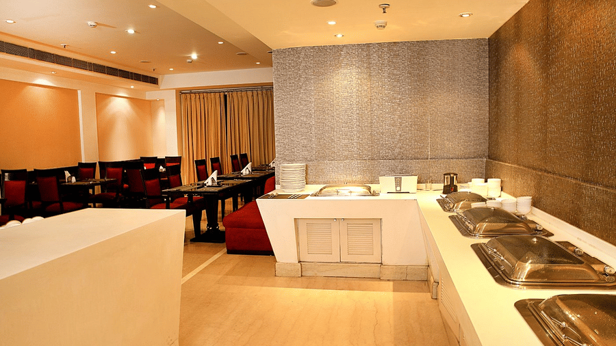 A buffet station with stainless steel servers is set up in the dining area at Eastlynn Collections Huda City Centre.