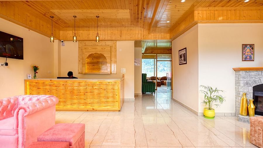 Well lit reception area with sofa and wood panelled ceiling - Clarks Inn Suites, Manali