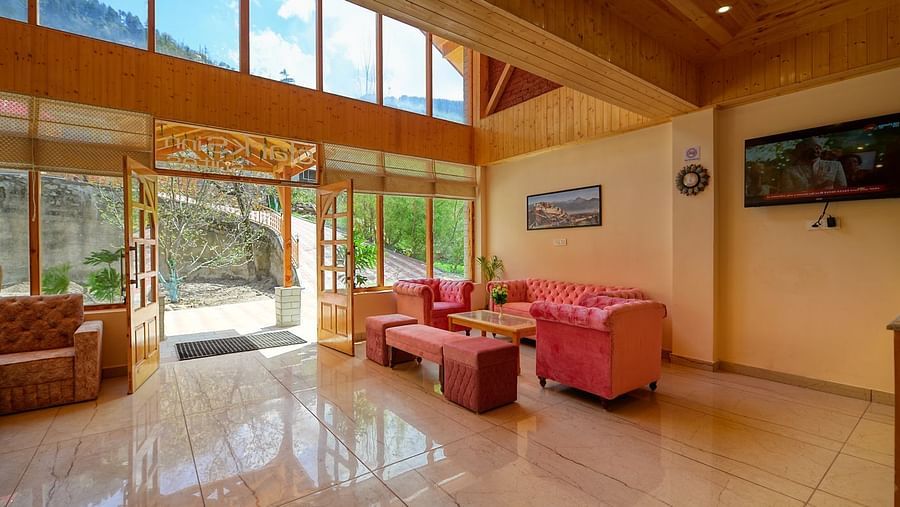 Lobby with sofa and ceiling high windows with mountain views - Clarks Inn Suites, Manali