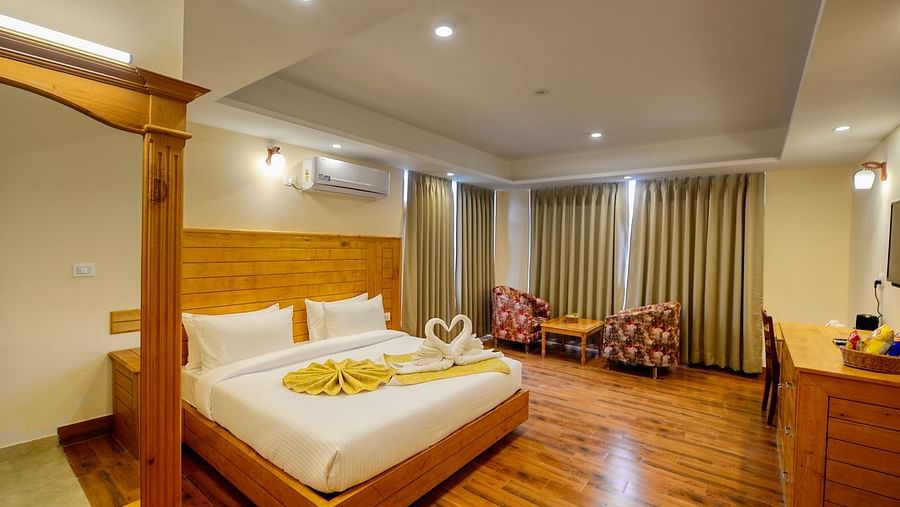 Well lit room with double bed and seating arrangement - Clarks Inn Suites, Manali