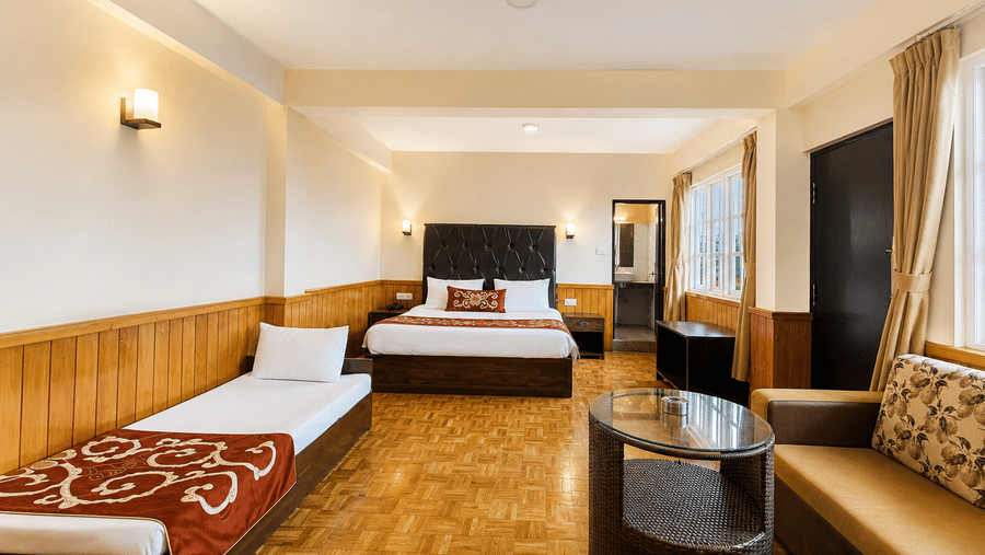 Premium Room at Orsino Karpo Retreat & Spa, Lachung featuring a double size bed, a single bed, a sofa with centre table and a wardrobe.