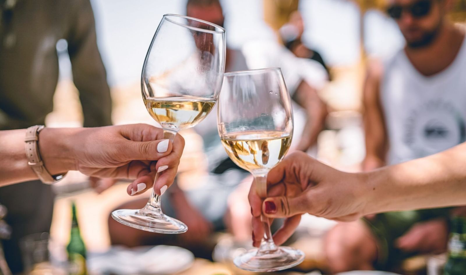 Group toasting with glasses of white wine at a celebration.