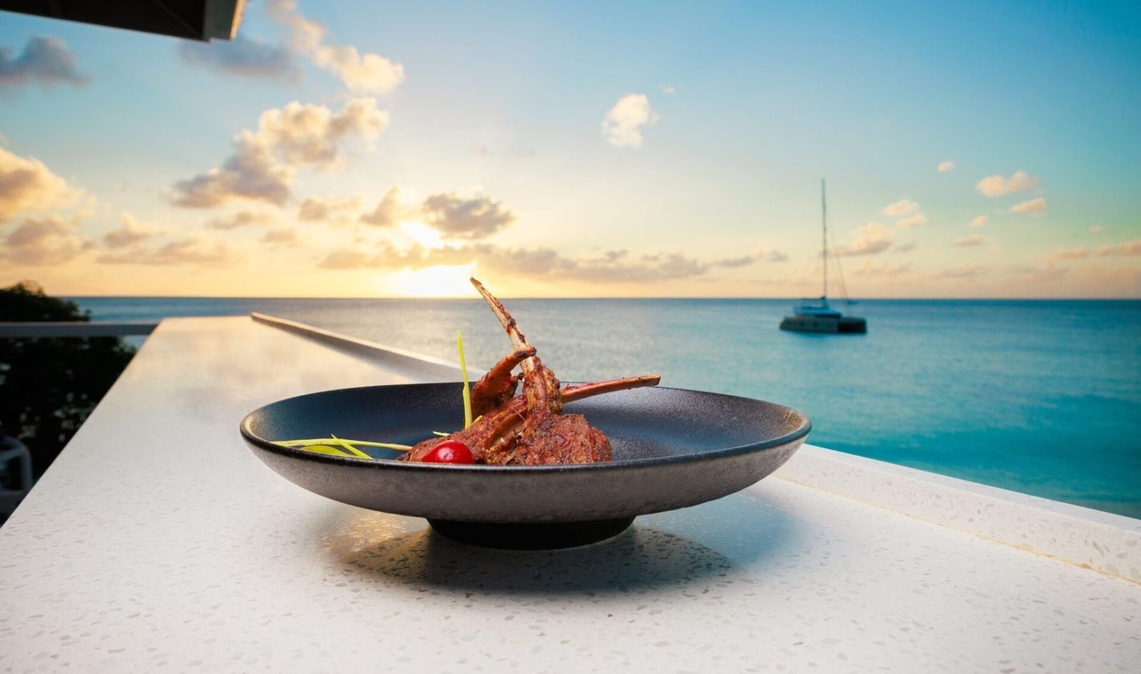 A gourmet dish served at sunset by the sea, with a yacht in the distance—perfect blend of fine dining and Caribbean tranquillity - Tamarind Hills Resort and Villas - Antigua