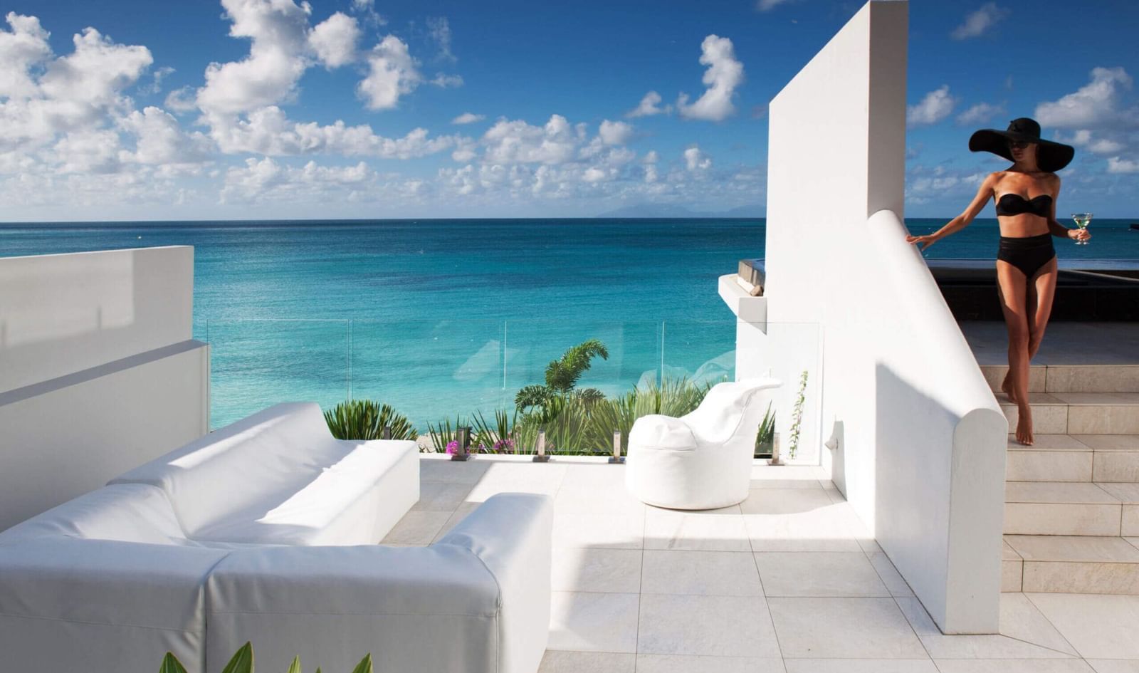 Woman on a terrace by the Caribbean Sea under a sunny sky.
