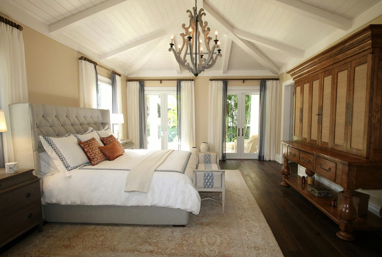 Side view shot of the bed with a chandelier hanging over the double bed.