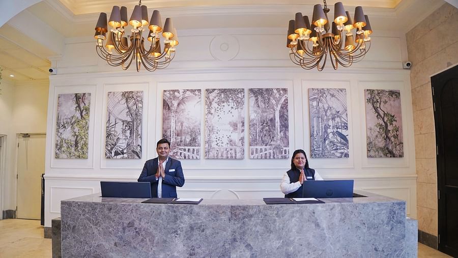 Two staff members standing behind the reception desk - Rhythm Gurugram