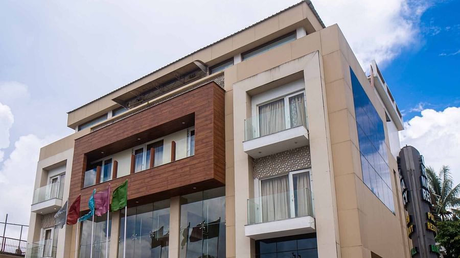 An exterior view of Mansha Hotel Regency with multiple levels and a clean architectural design under a bright sky.