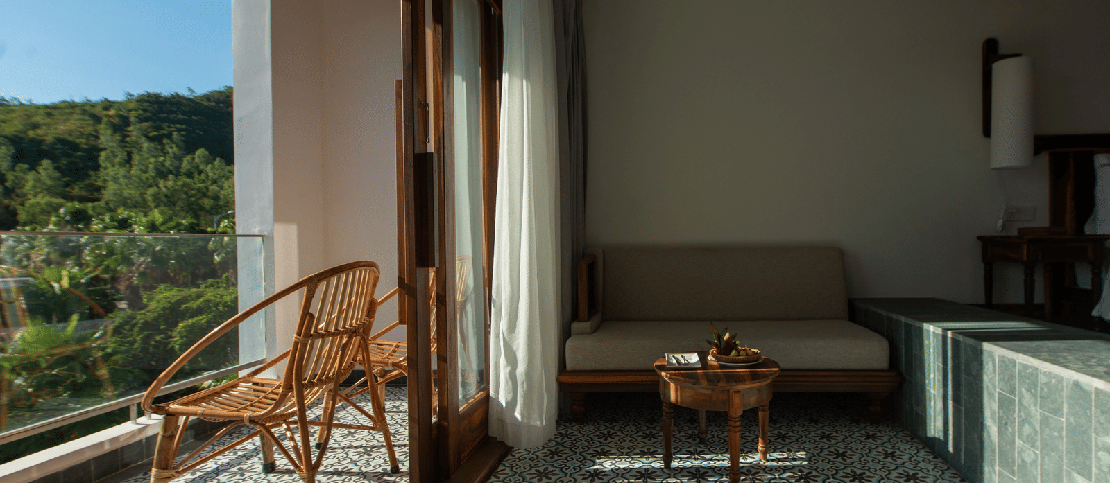 Balcony Room at Alibu Resort Nha Trang with seating area, garden view, and outdoor access through glass doors.