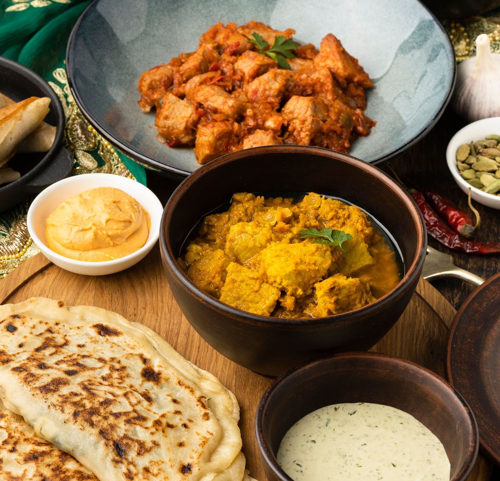 A top-down view of a variety of dishes placed on a wooden table.