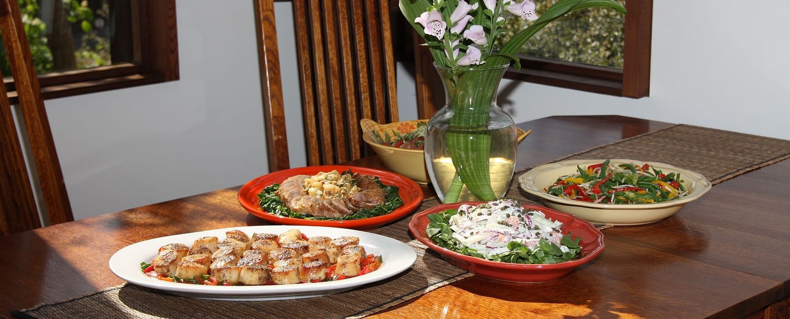 A table elegantly set with gourmet dishes and floral decor - Brewery Gulch Inn & Spa