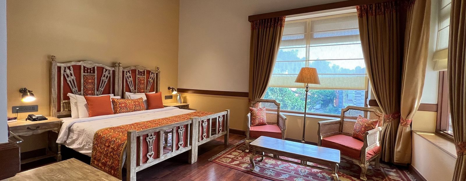  A comfortable Superior Lake Facing Room at Fishermen's Lodge, Bhimtal, featuring a wide open window with stunning views of the lake and surroundings.