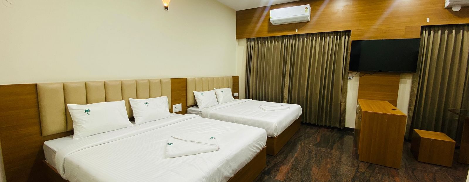 Elegant king-size bedroom with rich wooden flooring and soft lighting at Hotel Sahara Tree.