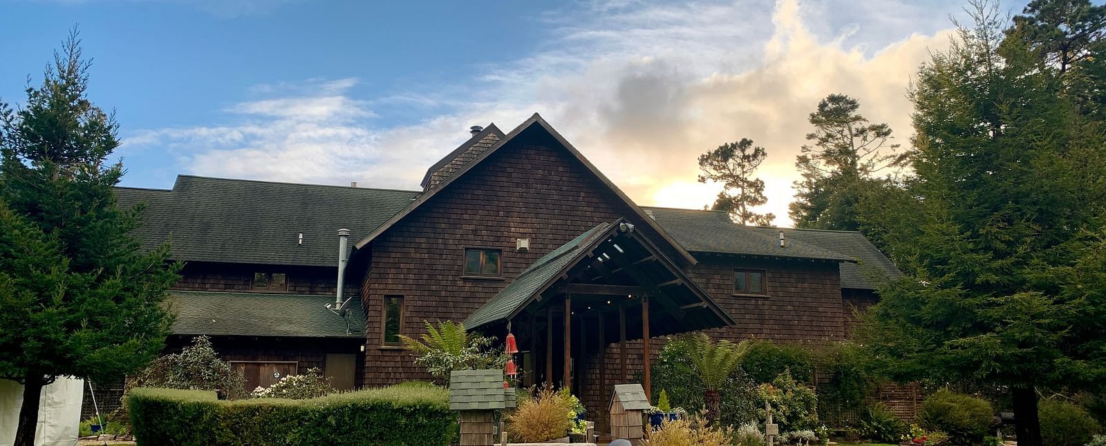 A rustic resort surrounded by greenery and a cloudy sky - Brewery Gulch Inn & Spa