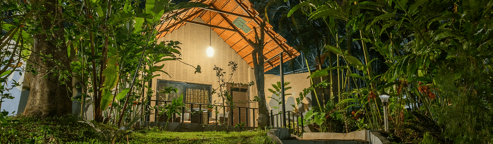 Night facade of an accommodation with a staircase leading to it at Coorg Jungle Camp Backwater Resort, Kushalnagar.