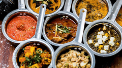 Small bowls of Indian cuisines placed next to chappati. 