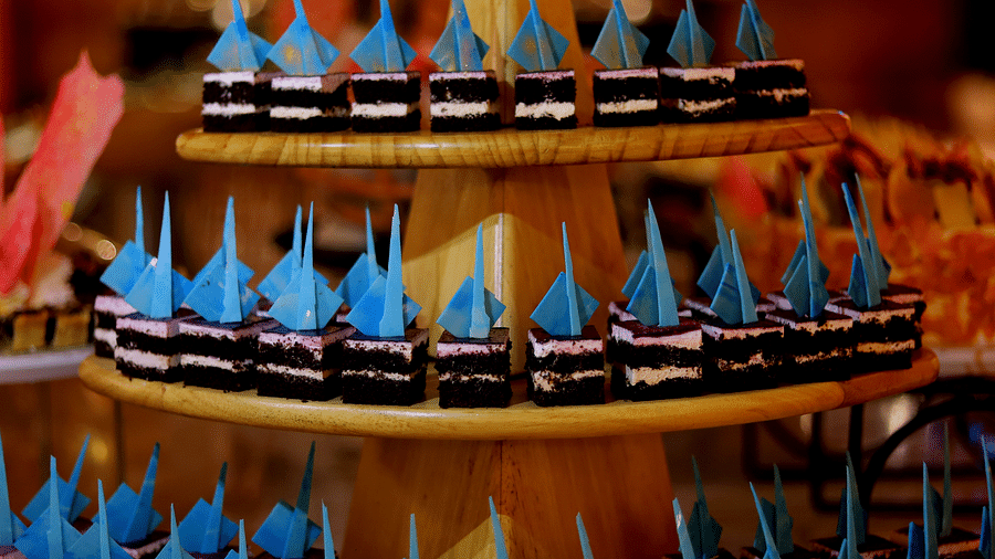A display of blue sailboat-themed desserts arranged on a tiered stand at Themis Barbecue House, Ambience Mall, Gurugram