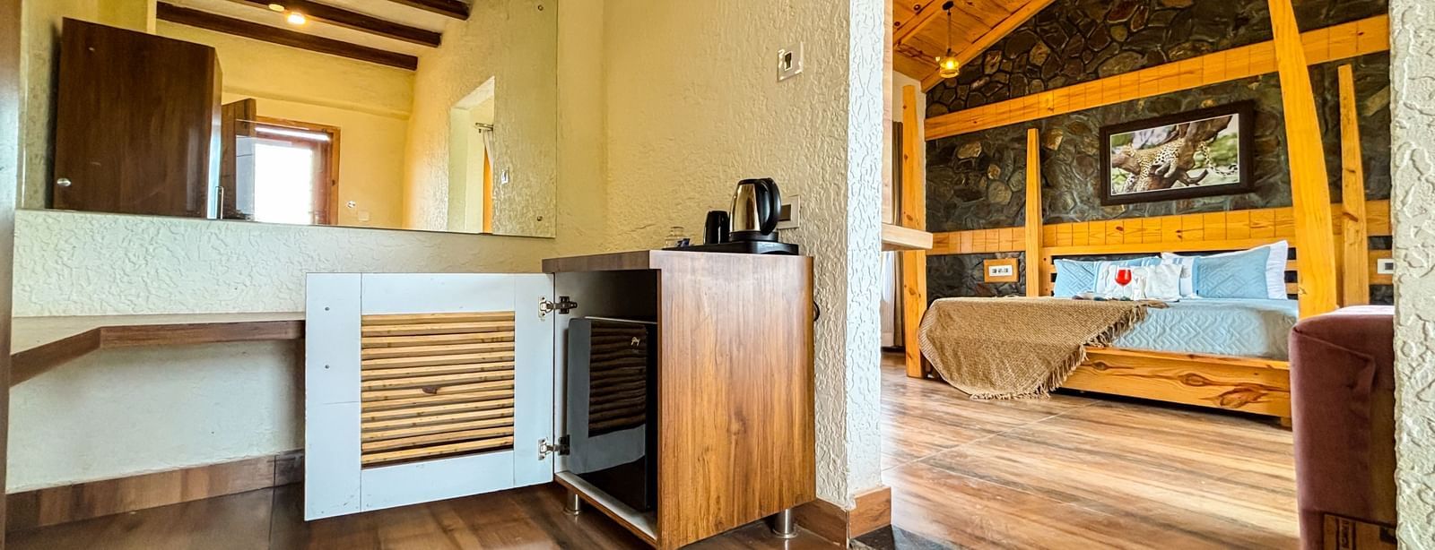 Resort room with open layout, wooden flooring, and stylish furniture at Corbett Nirvana Resort.