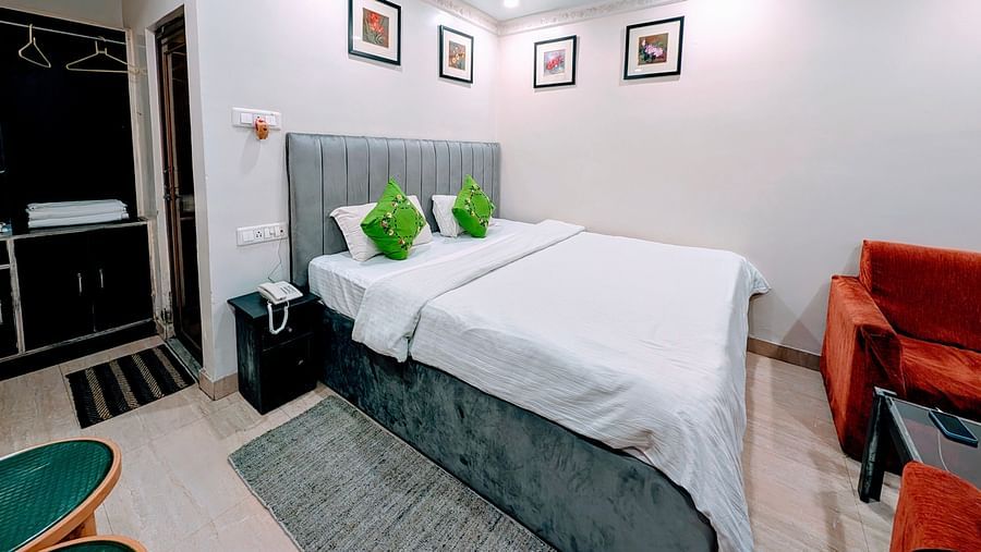 An image of a Cottage Room featuring a double size bed, bedside table, a seating area with sofa and table, and a wardrobe at Rangamati Garden Resort